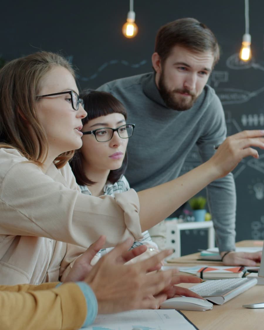 A marketing team gathered around a screen, discussing a draft
